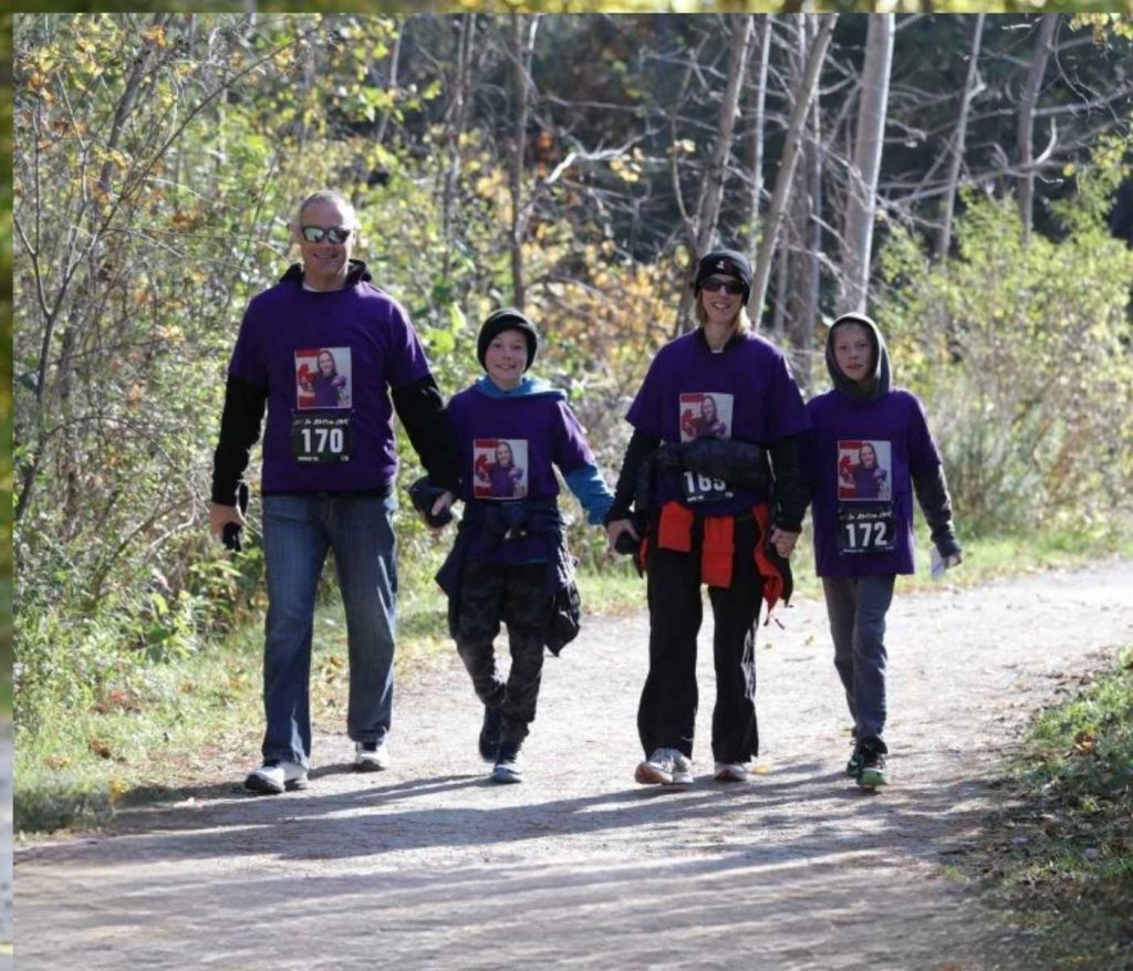 Family walking together on a wooded trail for the Art In Motion Virtual Charity Race